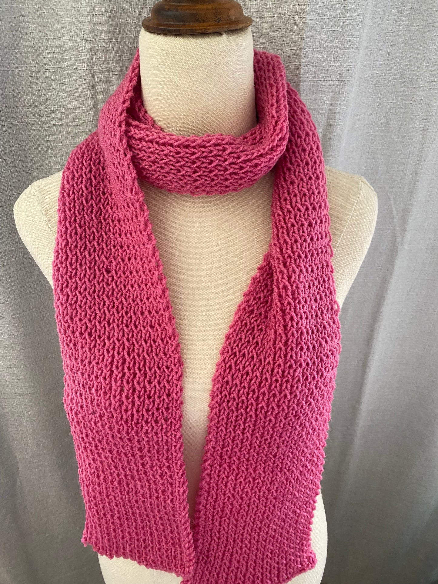 Genuinely hand knitted scarf in berry pink.